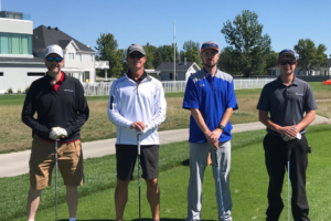 4 employees pose at a golf event