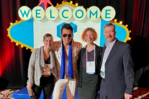 Four employees pose with an Elvis impersonator
