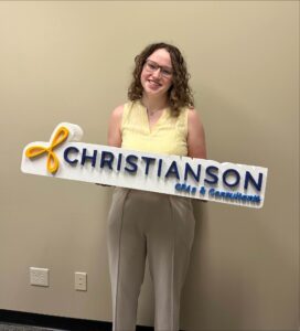 young woman with Christianson CPA sign in her hands