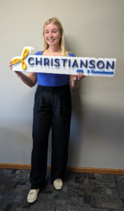 young woman with Christianson CPA sign in her hands