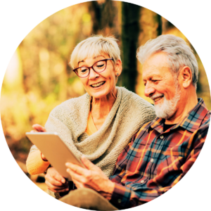 Elderly couple smiling and looking at an ipad