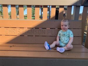 Child sits at bench that reads "Christianson PLLP"